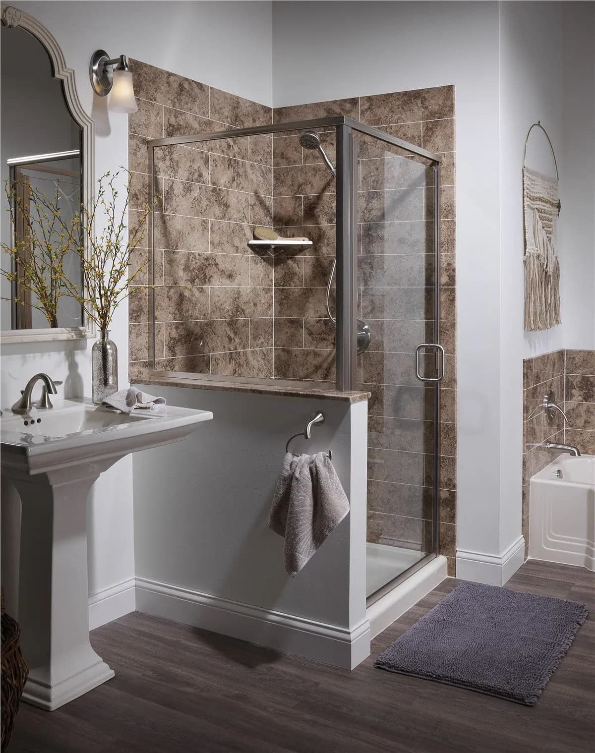 Modern bathroom featuring a spacious walk-in shower with a clear glass enclosure, textured stone-look tile walls, brushed nickel fixtures, and a bright, contemporary design with wood-look flooring and elegant finishes.